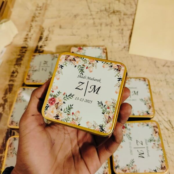 Hand holding a Luxury Wedding Tin Box with Gold Edging and Floral Print Design